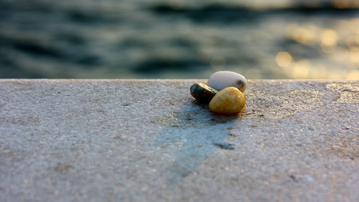 a couple of rocks sitting on top of a cement wall
