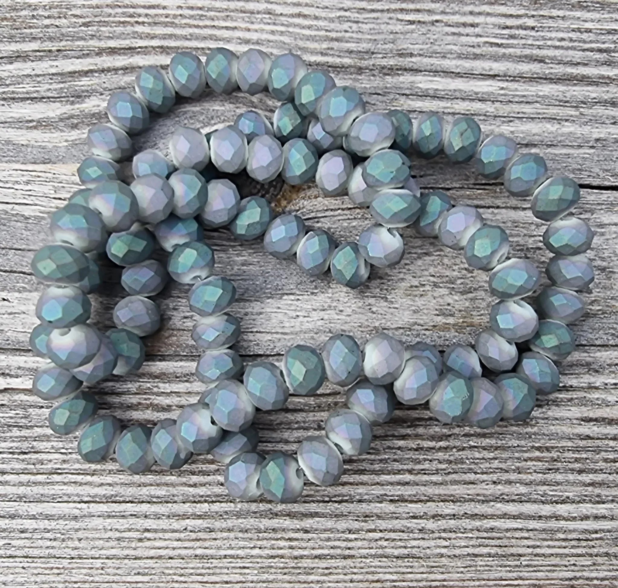 Facetterade glaspärlor - Matt grå med lila/grönt skimmer 6x4mm 1 sträng Hilmas Pyssel