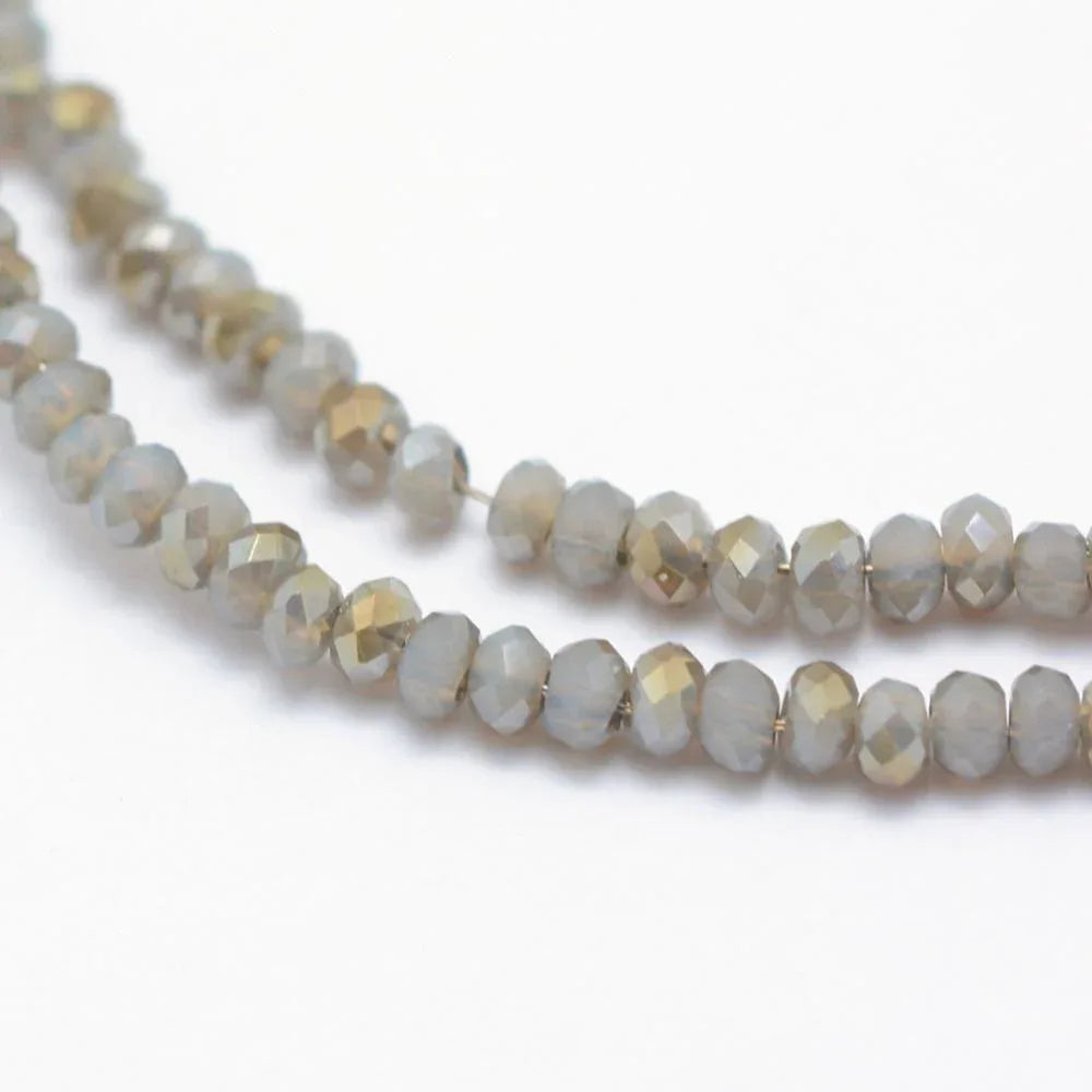 Facetterade glaspärlor - Grå med gröntlyster 2,5x1,5mm 1 sträng Hilmas Pyssel